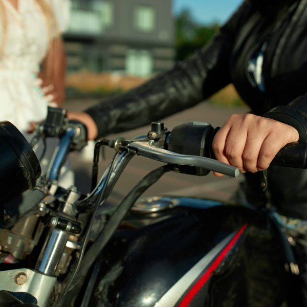 Two girl friends stay near motorbike. Sell motorcycle concept in the city. Fast delivery in covid time in town.